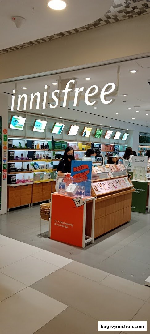 Innisfree store interior with products displayed and staff assisting customers.