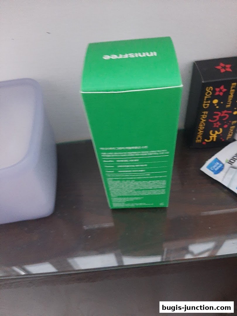 A green Innisfree product box with text on the side, next to other items.