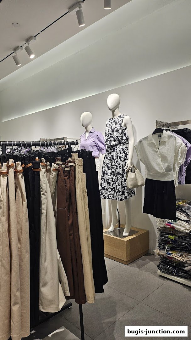 Mannequins display stylish outfits in a well-lit clothing store.