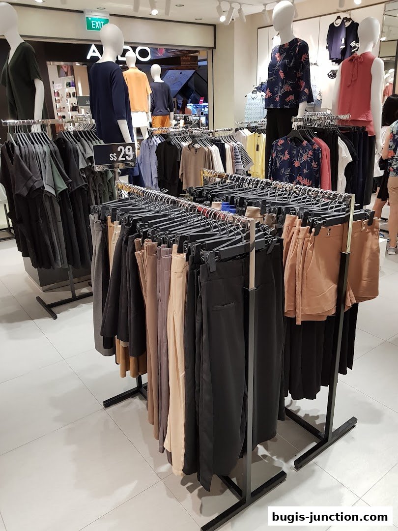 A retail store interior displaying racks of women's clothing and mannequins.