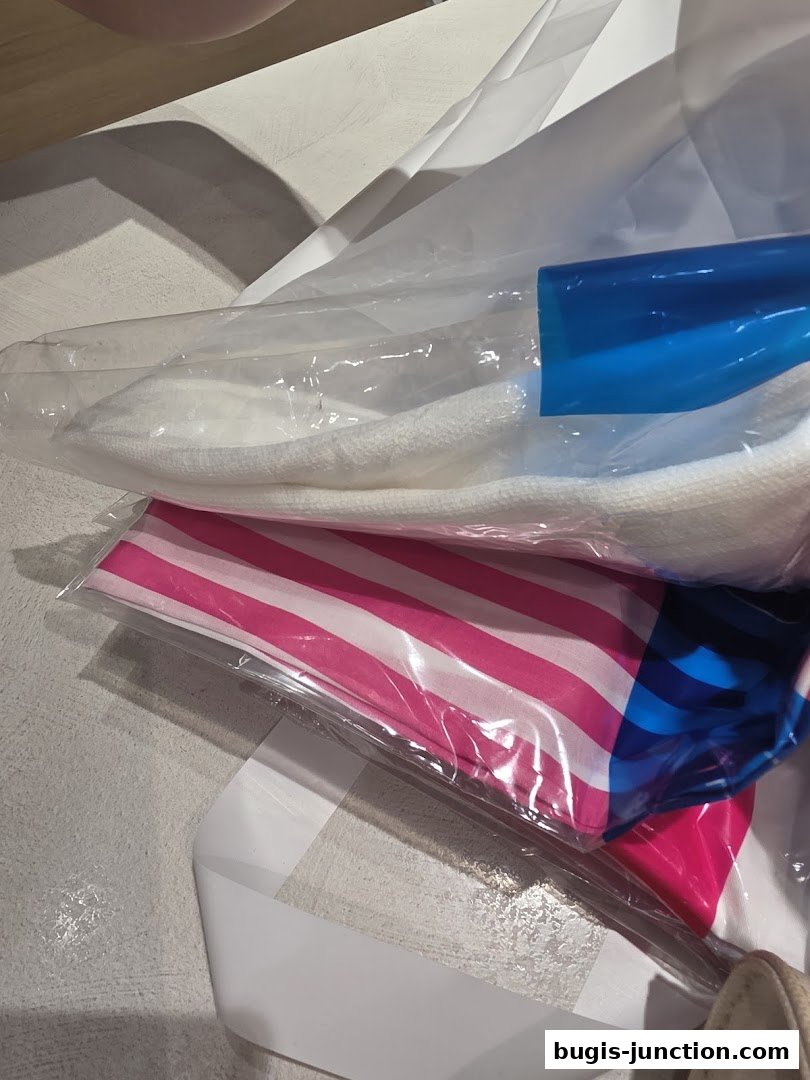 A close-up of white and pink striped fabric items in plastic packaging.