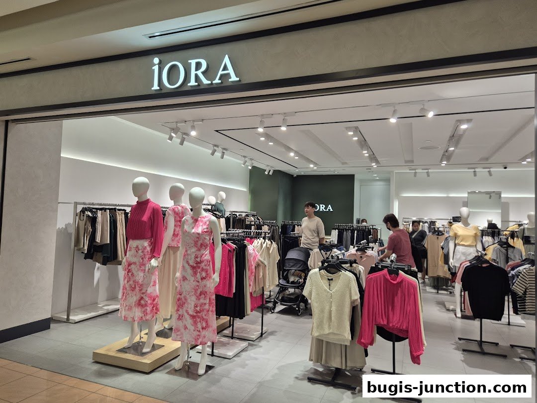 The iORA Bugis Junction shop front displays mannequins in stylish outfits and racks of clothing.