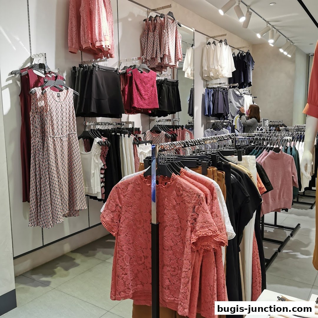 Interior view of a clothing store displaying dresses, tops, and skirts on racks.