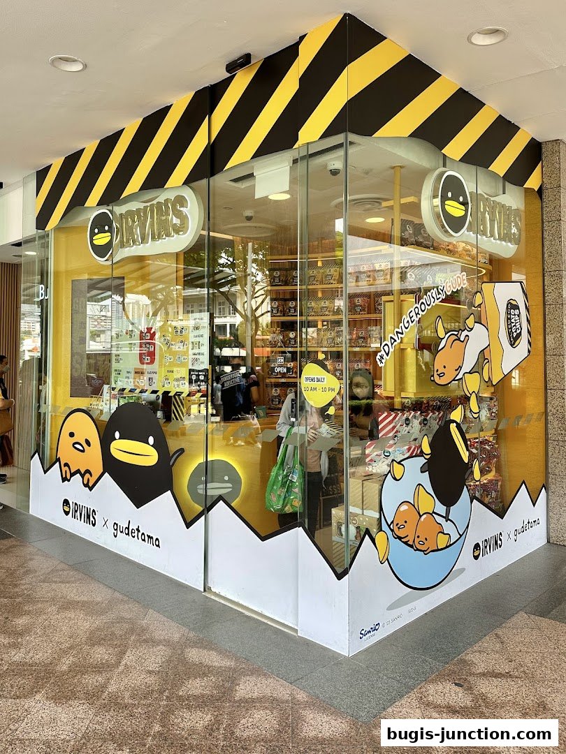 The IRVINS x Gudetama shop front features bright yellow and black hazard stripes and cartoon characters.