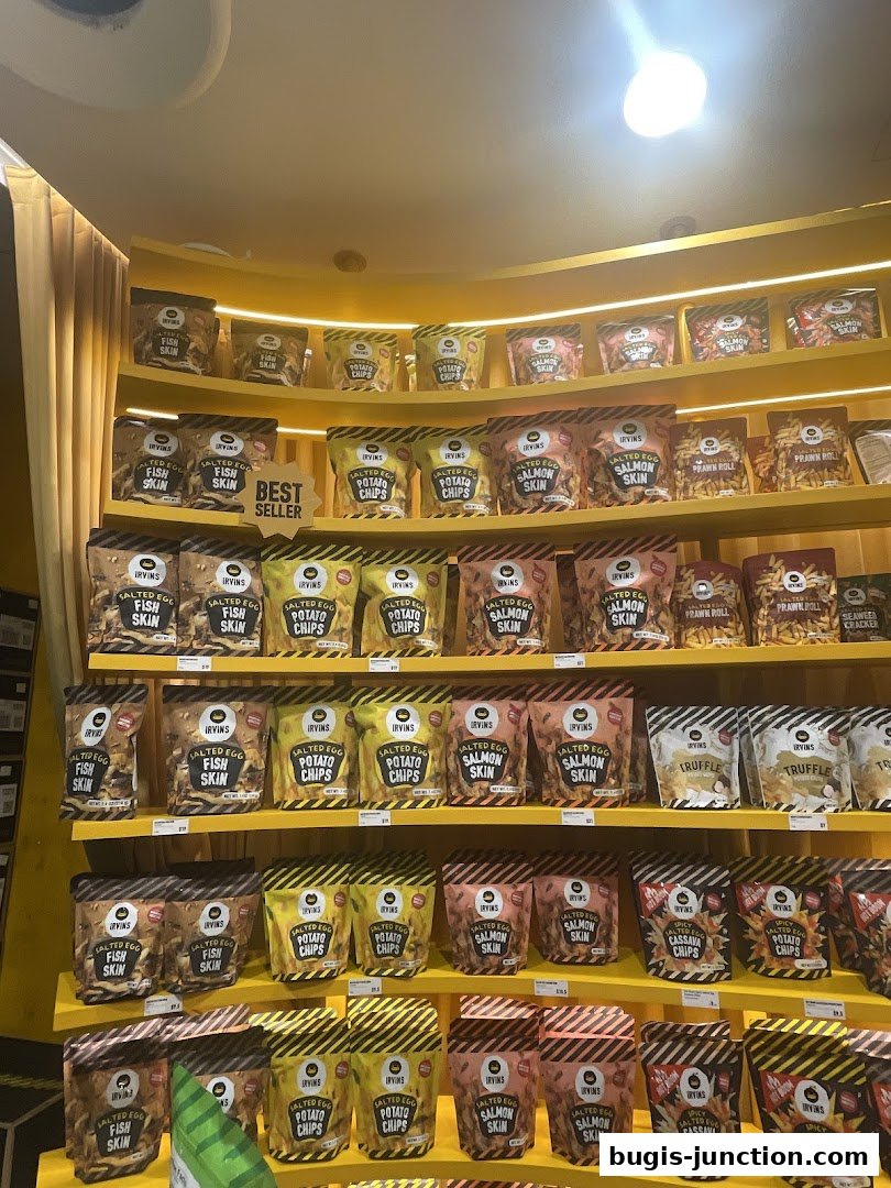 Shelves stocked with various flavors of IRVINS snacks, including salted egg potato chips and fish skin.