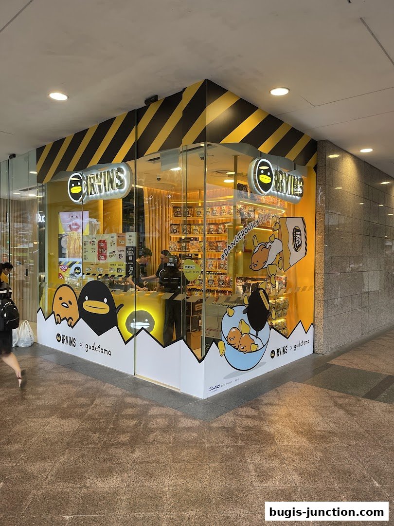 The IRVINS shop at Bugis features a bright yellow exterior with Gudetama characters and black and yellow hazard stripes.