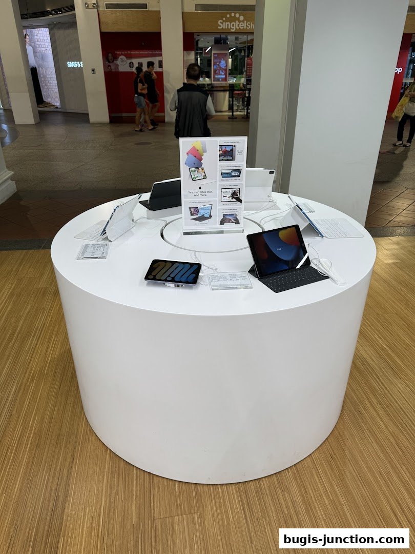 A display table showcasing various iPads and accessories in a retail store.