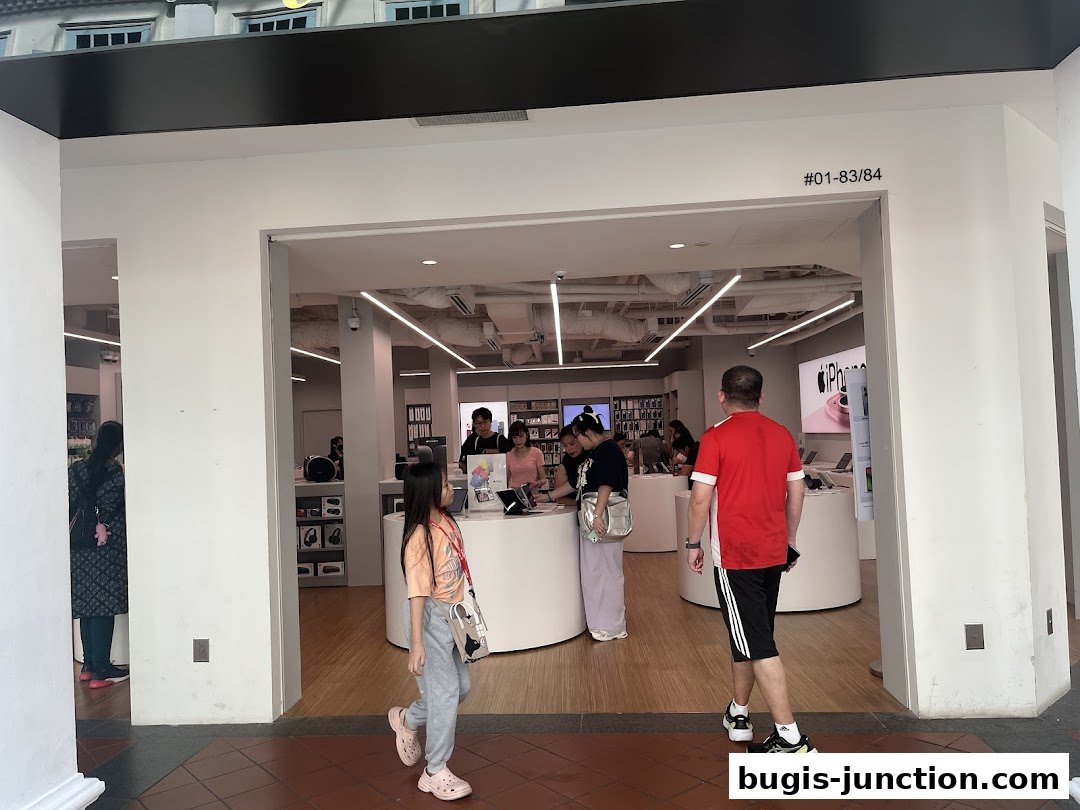 People entering an iStudio store, showcasing Apple products and a modern retail environment.
