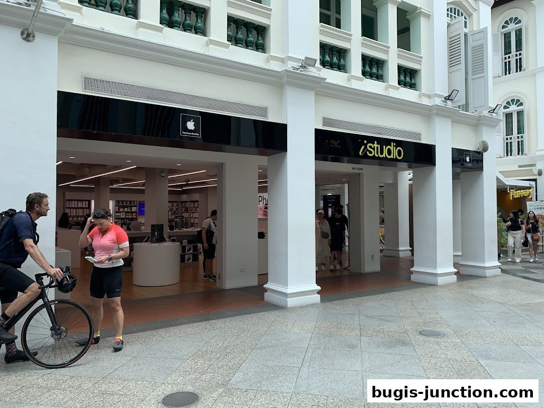 The iStudio Bugis Junction store front with Apple branding and people entering.