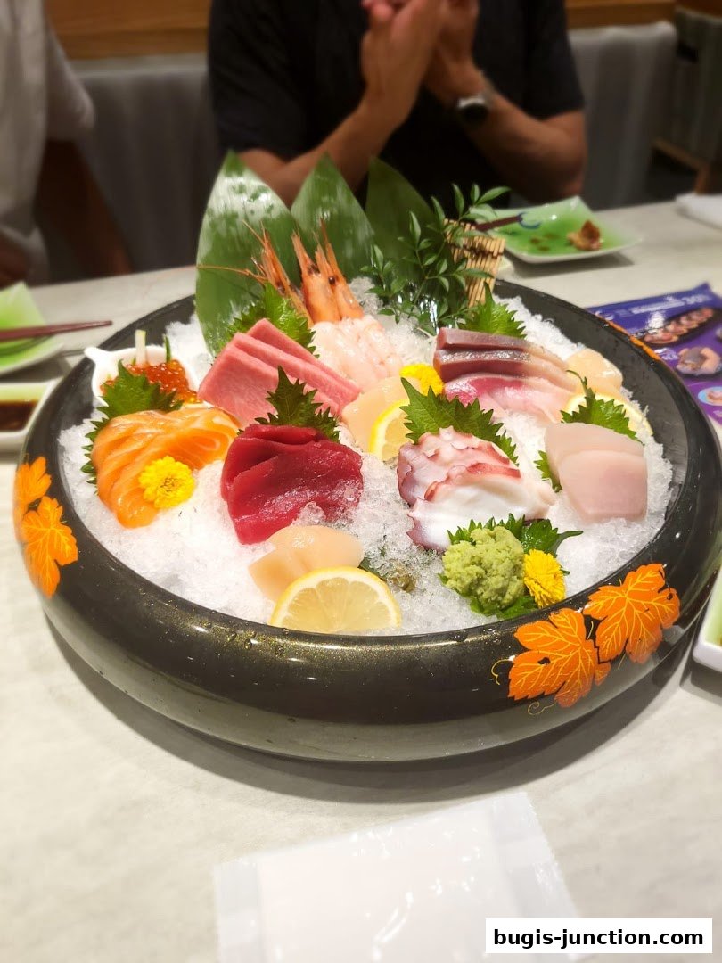 A large platter of assorted sashimi, including salmon, tuna, octopus, and shrimp, served on ice.