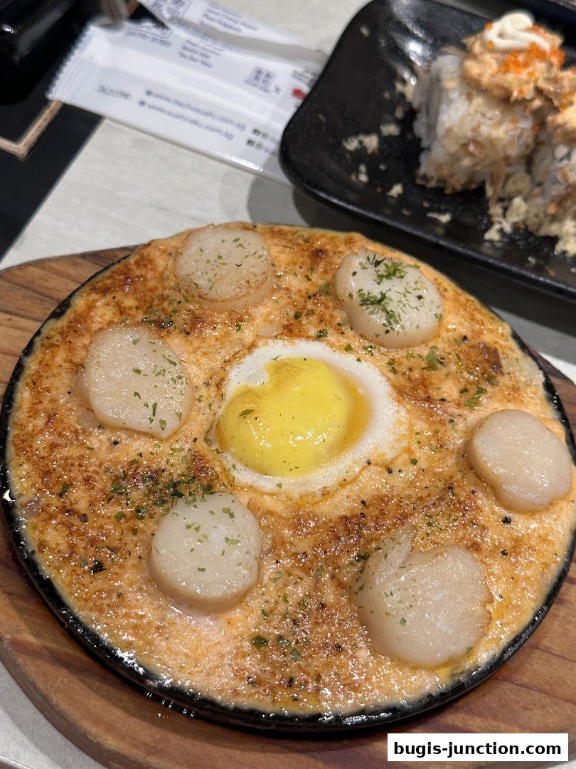 A close-up of a baked scallop dish with a fried egg in the center, garnished with herbs.