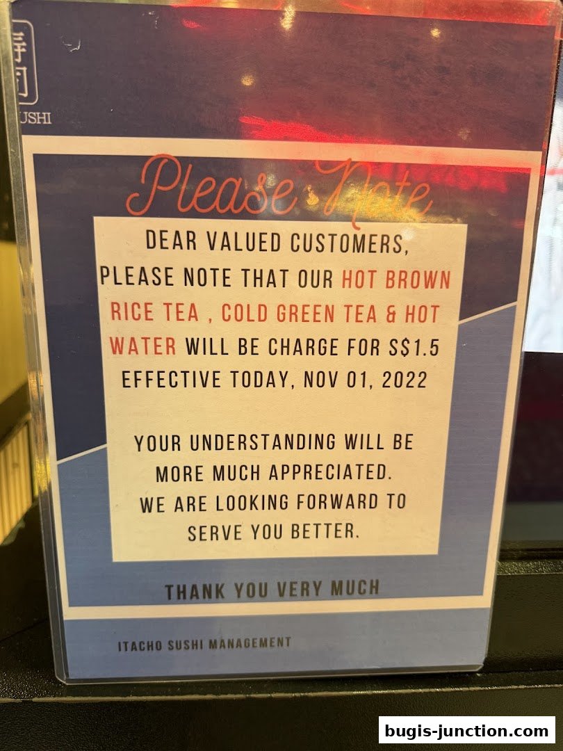 A sign from Itacho Sushi informing customers about a new charge for hot brown rice tea, cold green tea, and hot water.