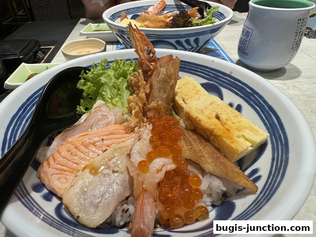 A close-up of a delicious sushi bowl with salmon, shrimp, and ikura.