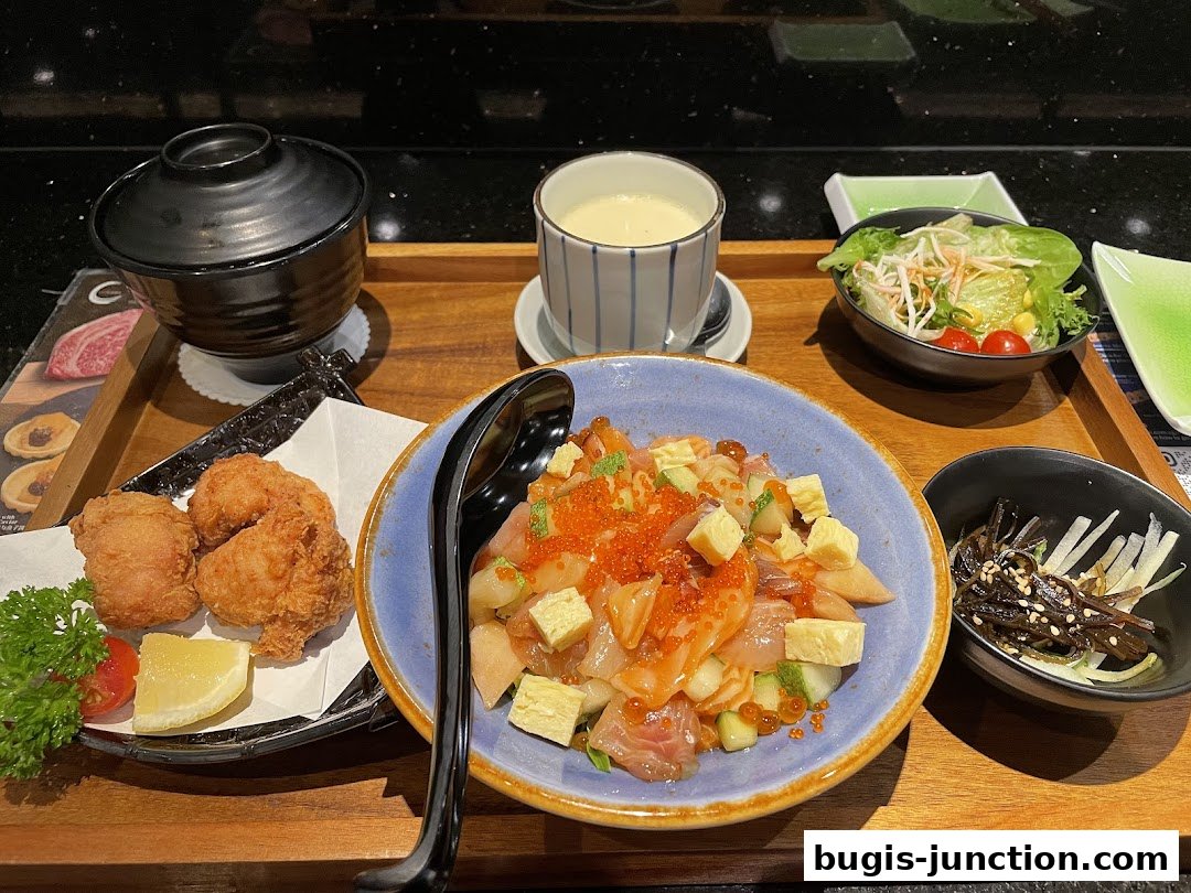 A delicious Japanese meal featuring chirashi sushi, fried chicken, soup, and salad.