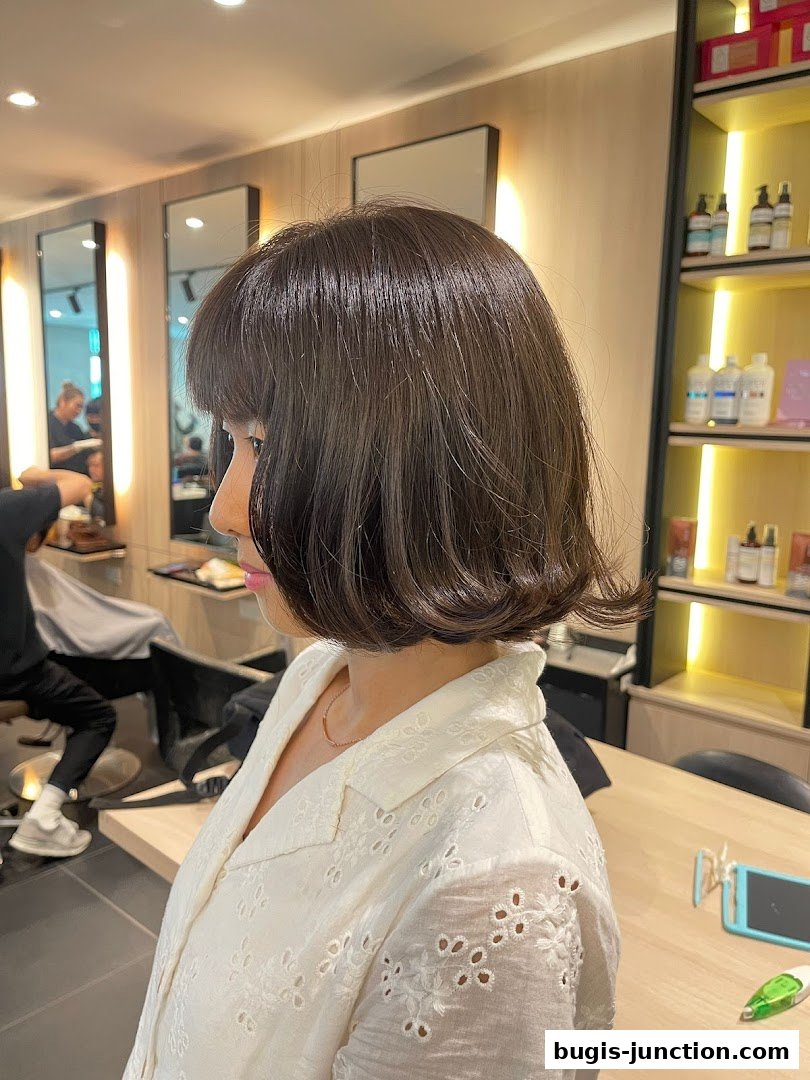 A woman with a fresh bob haircut at a hair salon.