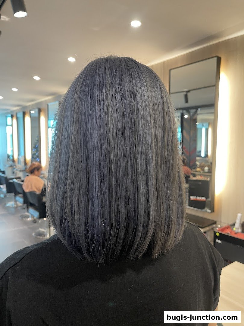 A person with a fresh, stylish grey bob haircut in a modern salon.