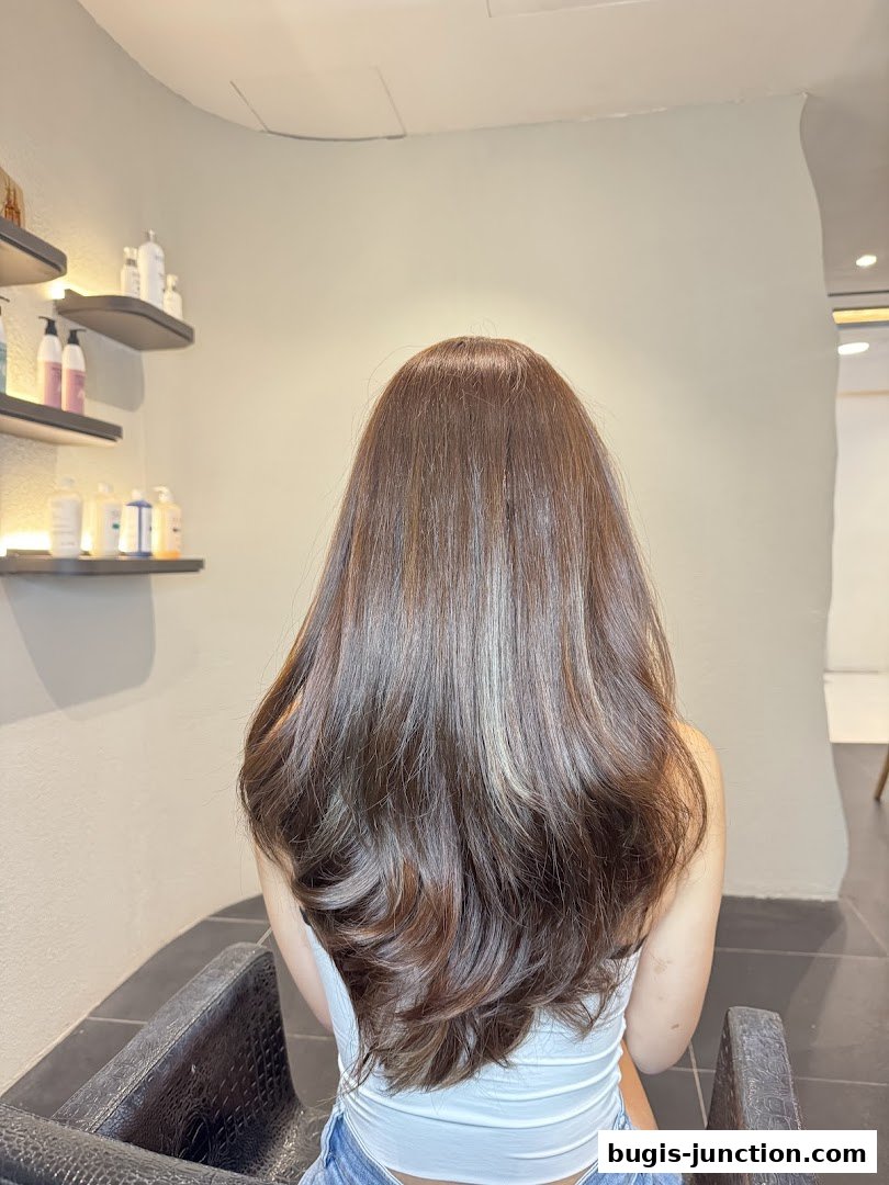 A woman with long, voluminous, and styled brown hair with subtle highlights.