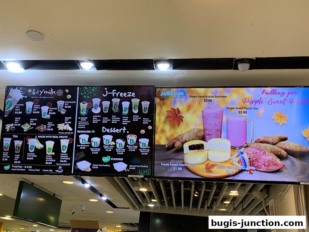A digital menu board displaying various soy milk drinks, frozen beverages, desserts, and sweet potato treats.
