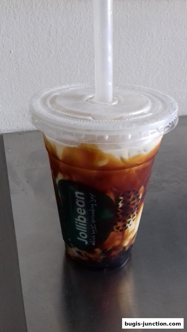 A close-up of a Jollibee drink with caramel swirls and a straw.