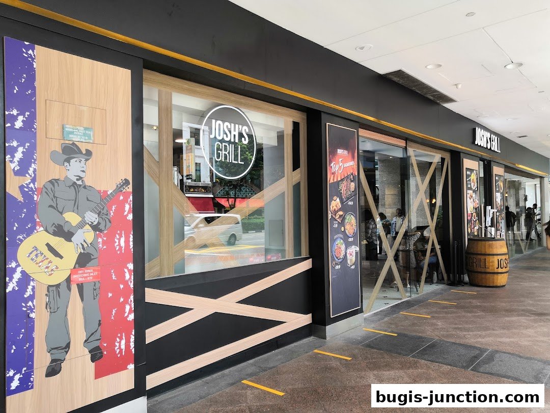 The exterior of Josh's Grill, a restaurant with a Texas-themed mural and large glass windows.