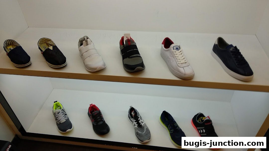 A display of various Kappa brand shoes on white shelves.