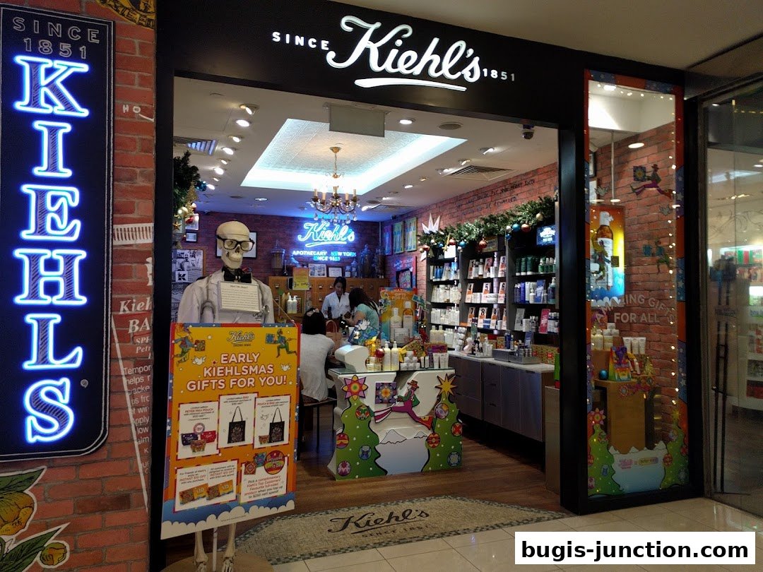 The entrance of a Kiehl's store with a skeleton mannequin and holiday decorations.