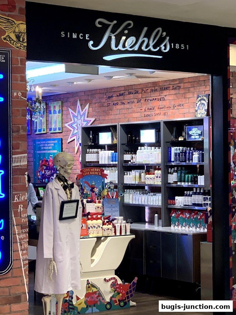The entrance of Kiehl's Bugis Junction store, featuring skincare products and a skeleton mannequin.