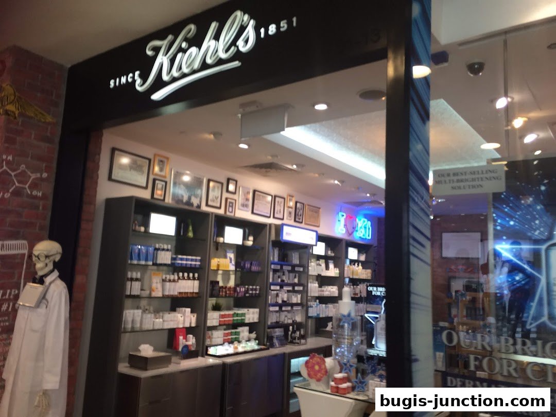 The exterior of a Kiehl's store with shelves of skincare products and a skeleton mannequin.