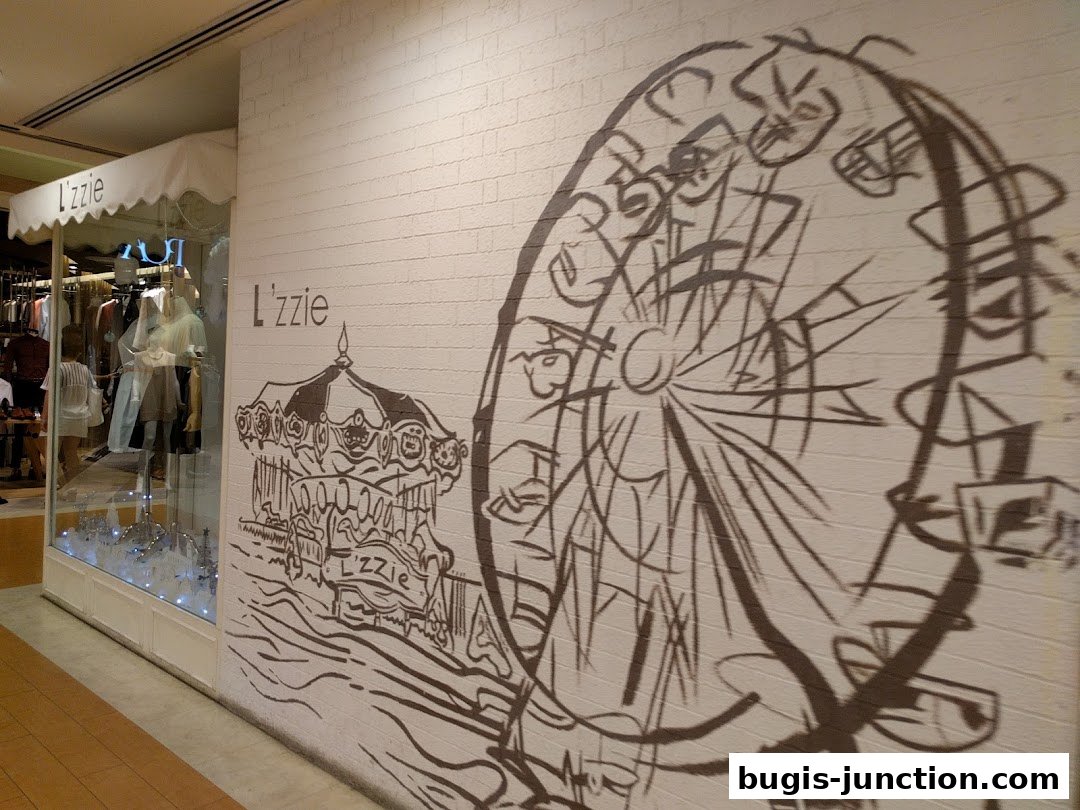 The storefront of Lzzie, featuring a display window and a mural of a carousel and Ferris wheel.