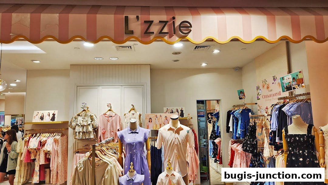 The L'zzie shop front displays a variety of women's clothing on racks and mannequins.