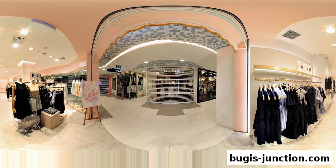 A panoramic view of a clothing store with mannequins and racks of apparel.