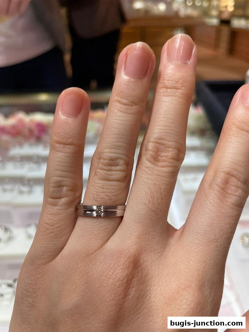 A close-up shot of a hand wearing a diamond-accented ring from Lee Hwa Jewellery.