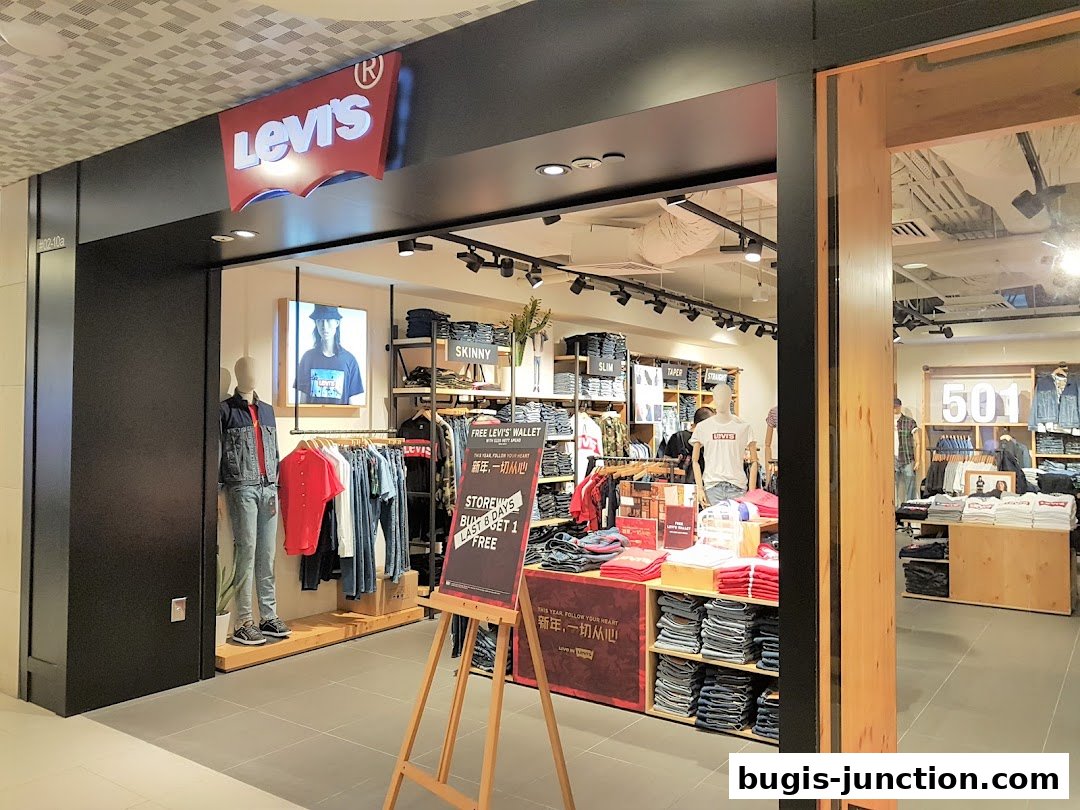 The entrance of a Levi's store showcasing denim jeans, t-shirts, and a mannequin.