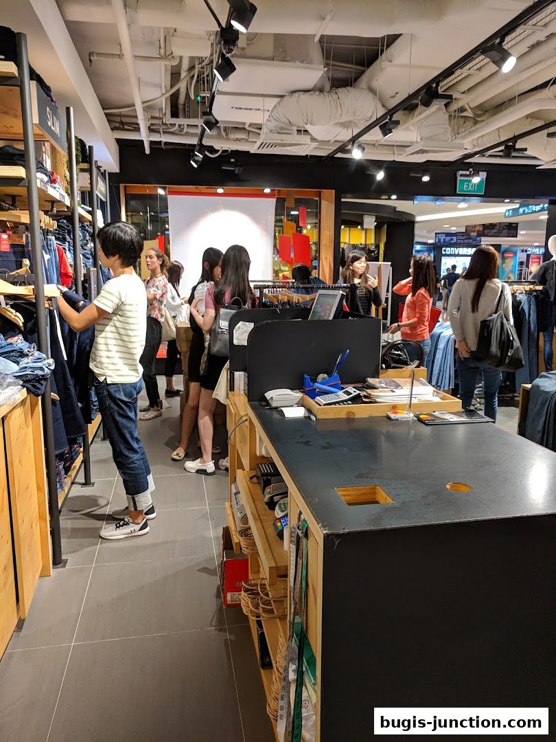 Customers browsing jeans and other apparel inside a Levis store.