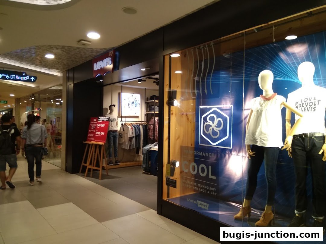 The Levis store entrance with mannequins in the window and a promotional sign.