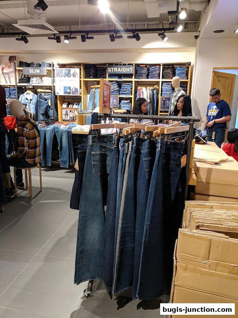 Interior of a Levi's store showcasing various denim jeans and apparel with customers browsing.