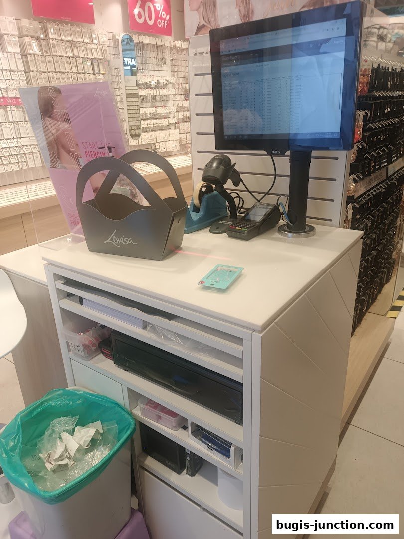 A retail counter at Lovisa with a computer, scanner, payment terminal, and shopping baskets.