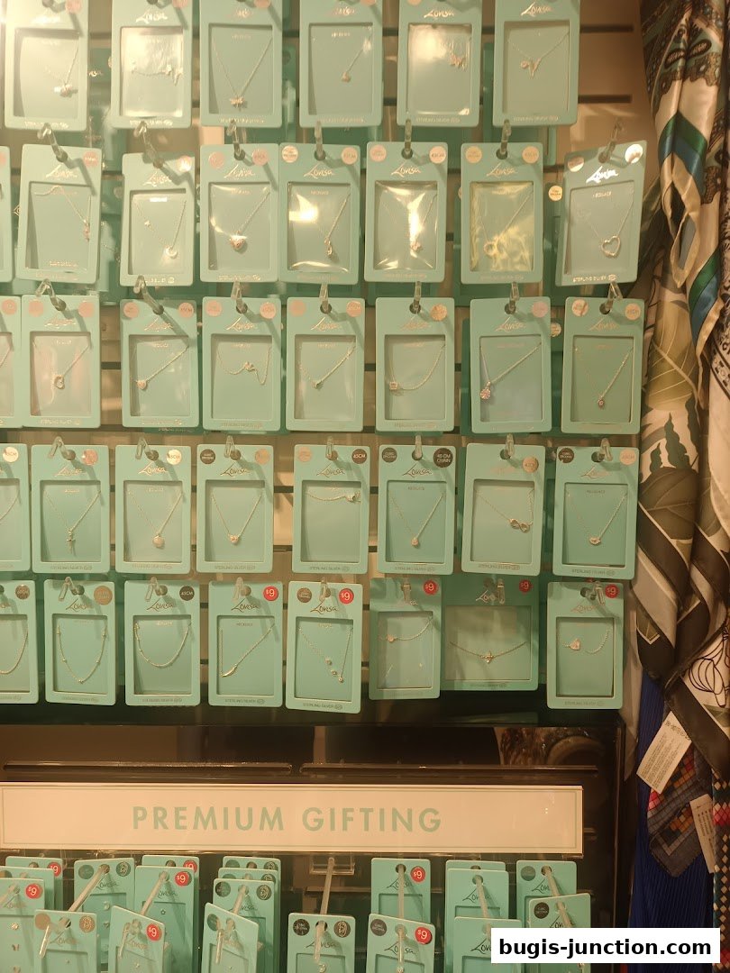 A wall display of packaged necklaces and a sign for premium gifting.