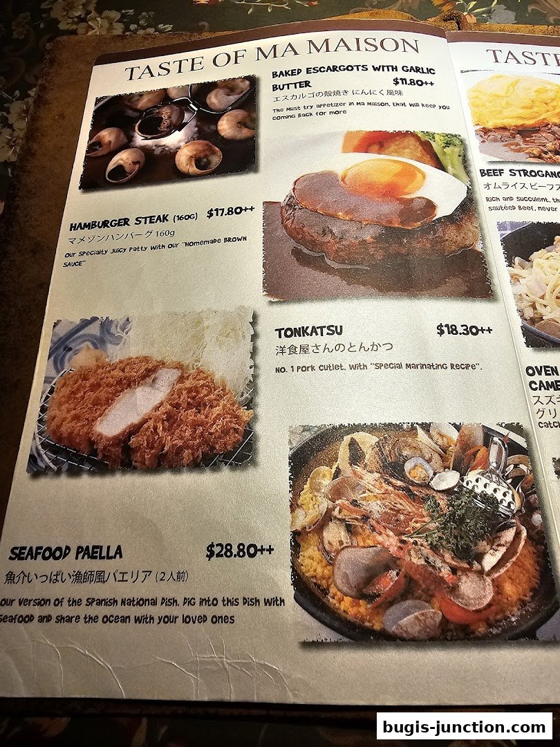 A menu from MA MAISON featuring dishes like escargots, hamburger steak, tonkatsu, and seafood paella.