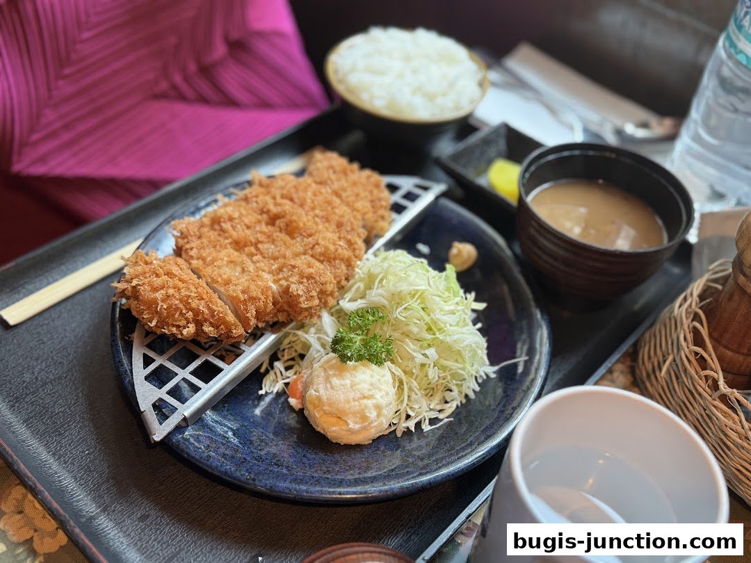 A delicious meal featuring crispy fried chicken, rice, miso soup, and salad.