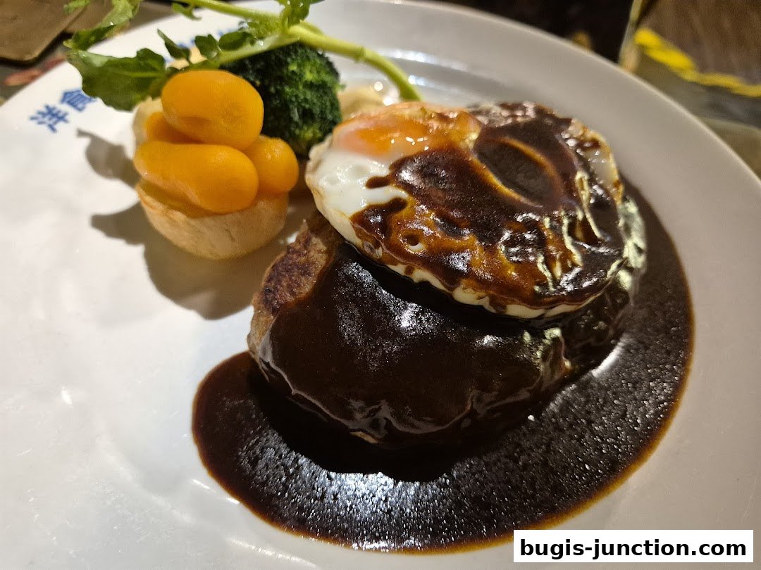 A delicious hamburger steak topped with a fried egg and rich sauce, served with vegetables.