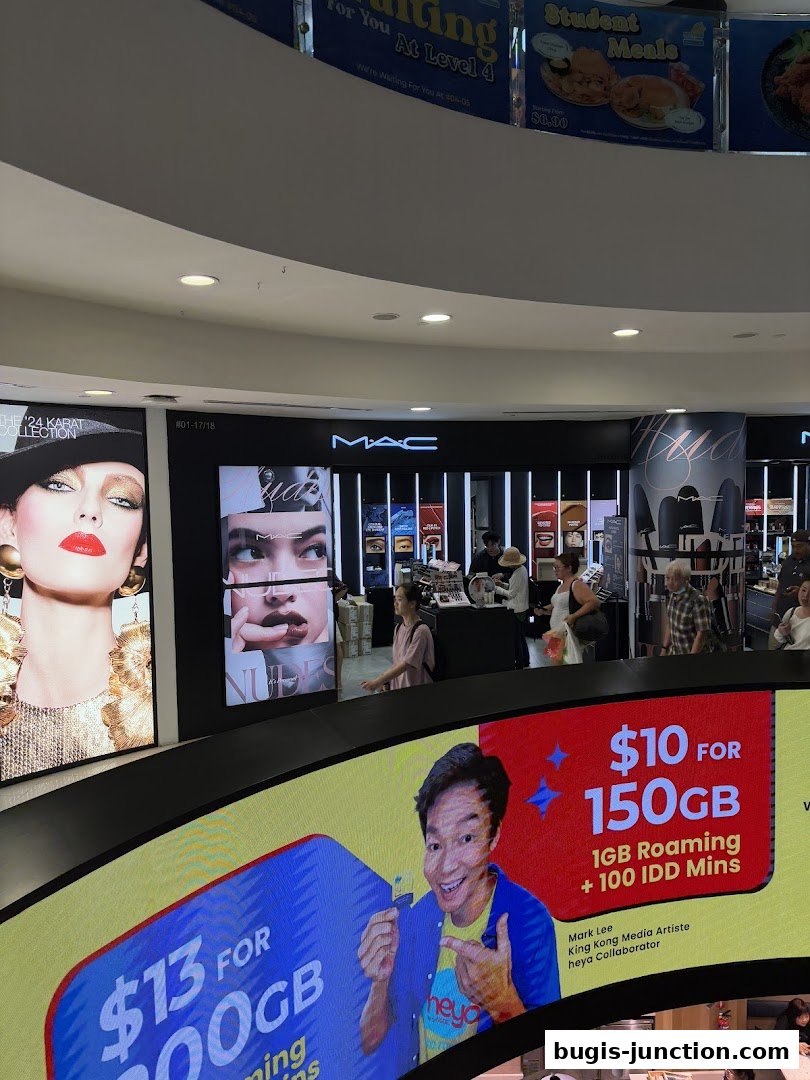MAC Cosmetics store interior with makeup displays and promotional visuals.