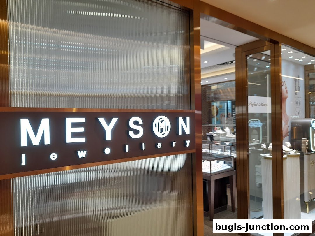 The illuminated sign for Meyson Jewellery is displayed on a textured glass facade.