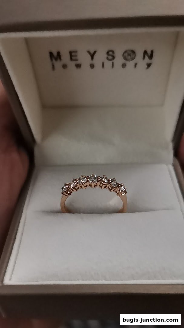A rose gold ring with diamonds displayed in a Meyson Jewellery box.