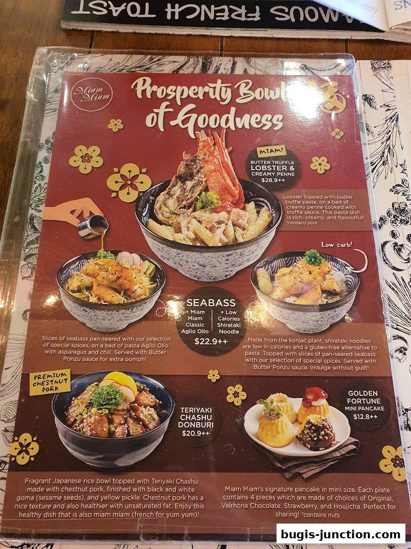 A menu featuring 'Prosperity Bowls of Goodness' with lobster, seabass, and pork dishes, plus mini pancakes.