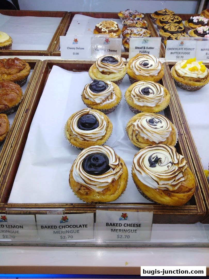 A display of various baked goods, including meringues and pastries, in a shop window.
