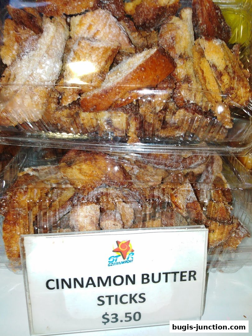 Close-up of cinnamon butter sticks in plastic containers, with a price tag.