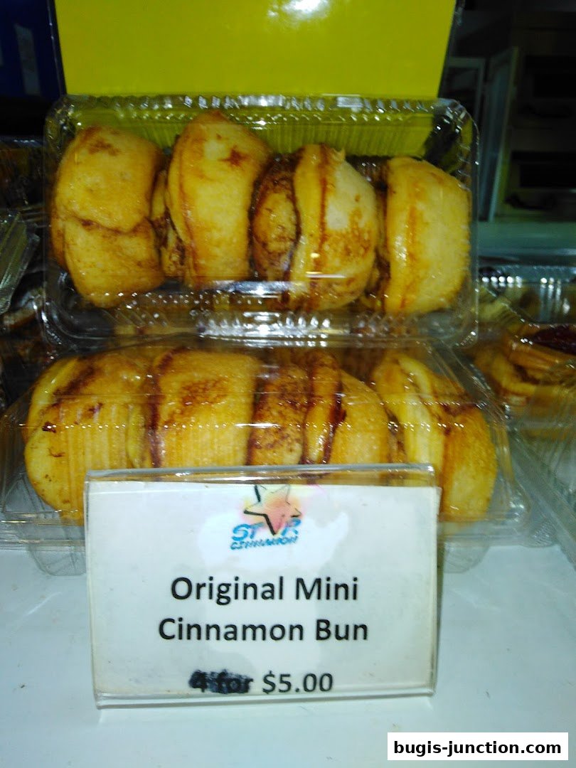 A close-up of mini cinnamon buns in clear plastic packaging with a price tag.