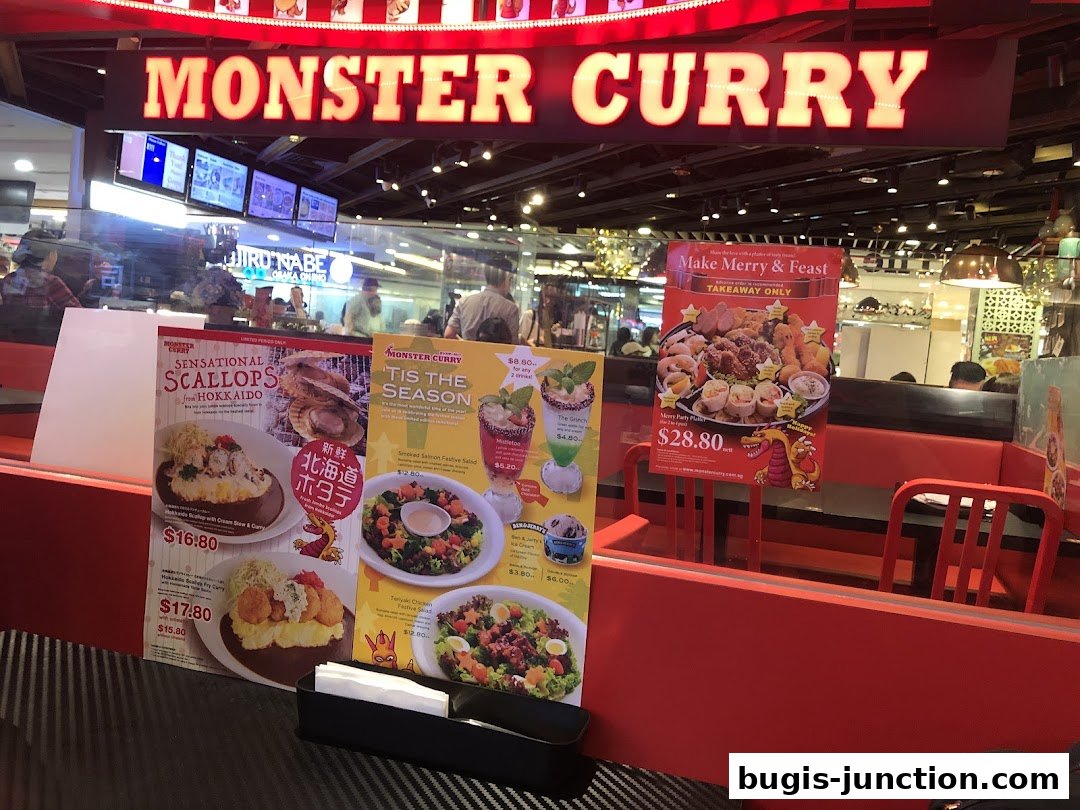 Monster Curry shop front with promotional posters for scallops and festive platters.