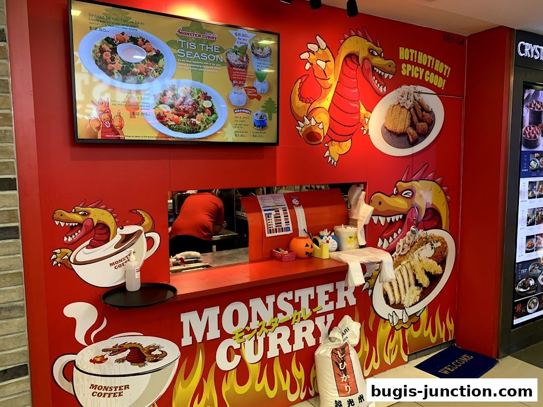 Monster Curry shop front with vibrant dragon graphics and menu displayed on a screen.